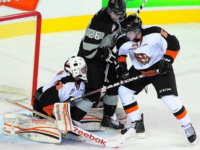 Medicine Hat Tigers defenceman Tyler Lewington (5) tries to clear fellow Park product Greg Chase (26) of the Calgary Hitmen away from his goalie. Both former Sherwood Park Kings players are hoping to hear their names called this weekend at the draft. Photo by Jim Wells/QMI Agency
