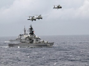 American navy helicopters fly above the Japanese destroyers JDS Hiei and JDS Kongo during manouvres in the Pacific.
