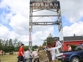 J-R DAOUST • for Northern News
 Northern College students and professors unload and install the K.L. Commemorative Plaque onto the Toburn Mine property sign as they prepare for Saturday’s unveiling.