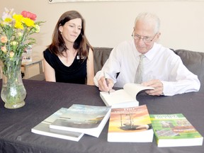 World track running record holder Earl Fee, right, autographs copies of his books for Chatham-Kent Library branch manager Robin Stewart during his visit to Chatham, Ontario on Thursday June 27, 2013 as guest speaker for a local chapter of CARP. Fee started running after retirement as a way to live a healthy life and at 84 he's training for an upcoming world meet in Brazil in October. VICKI GOUGH/ THE CHATHAM DAILY NEWS/ QMI AGENCY