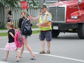 Crossing guard Bill Brown waits for a pair of girls to cross Harder Drive on his last day of work. After 15 years, Brown retired from his job.

W. BRICE MCVICAR The Intelligencer