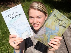 17-year-old Josie Neven-Pugh holds up her new novel Dragon Wing Take Flight after publishing the sequel to her first book Dragon Eye The Pupil.
