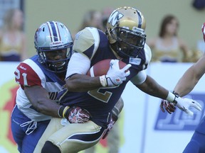 Winnipeg Blue Bombers returner Jovon Johnson is tackled by Montreal Alouettes safety Mike Edem during a first quarter kickoff return in CFL action in Winnipeg on Thurs., June 27, 2013. KEVIN KING/Winnipeg Sun/QMI Agency