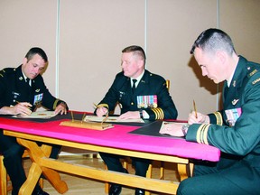 SEAN CHASE sean.chase@sunmedia.ca
2 Area Support Group commander Colonel Kerry Horlock (centre) watches as Maj. Jeff Spitzig (right) signs over command of 2ASG Operations Services to Lt.-Col. Chris Henderson during ceremonies at Garrison Petawawa Thursday. For more community photos please visit our website photo gallery at www.thedailyobserver.ca.