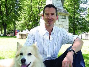 Steven Heighton and his dog Isla sit by the monument in Skeleton Park that formed the focus of one of the short stories in his book, The Dead Are More Visible, which was nominated for a Trillium Book Award.        ROB MOOY - KINGSTON THIS WEEK