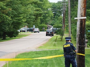 An OPP officer cordones off a stretch of Victoria Road leading to East Street in Petawawa, where police found an adult man dead and two women, one adult and one teenager, seriously injured on Friday morning. After a brief but massive manhunt, a 25-year-old suspect was arrested and now faces murder charges.