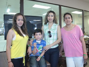 Eswin Garcia holds the newly-processed debit card for his family, from left, Tania Garcia, Claudia Garcia, Nayeli Garcia and Nayeli Garcia. The Garcia family has been staying in Nanton's evac centre since the flood, and are refusing deployment to University of Lethbridge dorms, since the distance is too far for Claudia to travel to her work at Cargill, near Aldersyde.