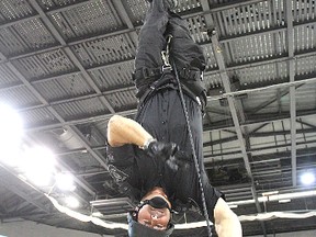 In a dramatic demonstration, Sgt. Darren Keuhl, from the Kingston Police emergency response unit, rapels upsidedown from the rafters during Friday's Sirens For Life event in which emergency service personnel descended on the K-Rock Centre to donate blood and display some of their departments' equipment.
Michael Lea The Whig-Standard