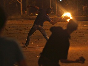 Protesters opposing Egyptian President Mohamed Mursi throw Molotov cocktails and stones at the national headquarters of the Muslim Brotherhood in Cairo's Moqattam district June 30, 2013. (REUTERS/Amr Abdallah Dalsh)