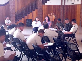 Paula Hopwood, front second from left, conducts a leadership training session with military officials in Guatemala with the help of an interpreter.