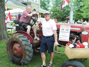 Stratford Perth Museum general manager John Kastner, seated, and board chair David Stones encourage the community to get a free ball of yarn and knit a square to help yarn bomb this antique tractor to mark the 100th International Plowing Match in September. While picking up some yarn, residents are also encouraged to walk through the new agricultural exhibit, Can You Dig It? (LAURA CUDWORTH, The Beacon Herald)