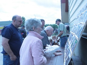 Evacuees look at aerial flood photos outside the Tom Hornecker Recreation Centre.