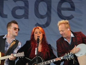 Wynonna Judd opens her set with the help of her husband and drummer Michael Scott “Cactus” Moser (right) and one of her guitarists in her band The Big Noise. (Randy Vanderveen/Special to the DHT)