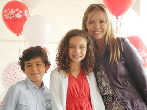 Avery Kadish, 11, (middle) poses with new Canadian citizens Juan and Adriana Pina, who took part in the official citizenship swearing in ceremony in Brantford on Monday, July 1, 2013. (VINCENT BALL Brantford Expositor)