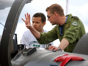 Capt. Bart Postma of the Royal Canadian Air Force speaks with Bryce Vance, left, of London near the cockpit of a Harvard II aircraft at the Great Lakes International Airshow on Saturday, June 29, 2013. Vance said the two talked about joining the air force, something Vance is interested in. (Ben Forrest, Times-Journal)