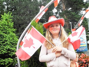 SARAH DOKTOR Simcoe Reformer
Taylor Numan, 12, waved a set of Canada flags from the Eising Garden Centre float during the Canada Day parade in Port Dover on Monday.