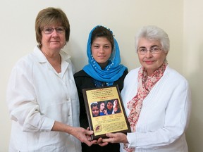 Marg Stewart, left, and Madeliene Tarasick, right, present a "Shafia Award" to Afghani Hosnia Salehzada in Kabul recently. The award, created by the Kingston chapter of the Canadians for Women in Afghanistan to honour and remember the slain Shafia women, was presented to Salehzada to continue her education. (Supplied photo)