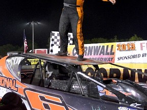 Rick Young photo
Carry Terrance of Hogansburg, NY, jumps on the hood of his car and waves the checkered flag, after winning the SUPER DIRTcar Big Block series race at Cornwall Motor Speedway.