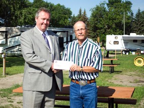 John Mitchell of Portage Mutual Insurance Company presents a cheque for $5,000 to Dale Brown, president of the Portage Ex, Tuesday. The funds were used to upgrade electrical and water at the Portage Ex Campground, allowing each site of be serviced with electrical outlets and water spigots. (ROBIN DUDGEON/PORTAGE DAILY GRAPHIC/QMI AGENCY)