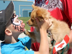 Chase Tessier gives his furry pomeranian friend Roxy a Canada Day kiss on Monday. The Timmins Museum: National Exhibition Centre was teeming with activity on Canada Day as it hosted activities and games for the entire family.