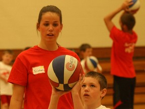 Connor Carruthers (top), 9, of Alliance Public School, shows total concentration as he lines up a shot under the watchful eye of Head Camp Counsellor Tristan Tremblay at the summer Hoop Camp Tuesday at Scollard Hall gym.