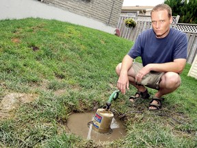 Homeowner Jay Poole spent the weekend pumping out the drain in his backyard due to the heavy rain this past weekend.   (DIANA MARTIN, Daily News)