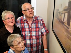 Joyce Rigutto, left, her brother Lloyd Cowan and their sister Shirley Cowan look at one of the historical photos on display at Cowan's Dairy in Brockvillle. RONALD ZAJAC The Recorder and Times