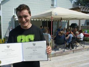 Jeffrey Fritz holds his Ontario Scholar and Ontario Secondary School diplomas at a barbecue and social gathering celebrating his successes in Owen Sound on Sunday.