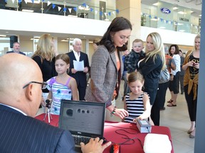 Operation Kidsafe’s station at Waterloo Ford allows parents to bring their children in to get a free print-out with their fingerprints and photo to give to police in case of an emergency. Photo by Doug Johnson/Edmonton Examiner