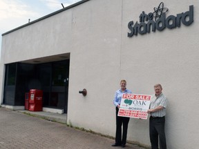 The Standard’s general manager Karsten Johansen holds a ‘For Sale’ sign with owner of Elliot Lake’s Oak Realty Donna Morris, who will handle the sale of the property.		         Photo by KEVIN McSHEFFREY/THE STANDARD/QMI AGENCY
