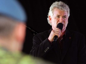 A Royal Canadian Air Force serviceman watches as John McDermott sings at the Afghanistan Repatriation Memorial at CFB Trenton, Ont. Wednesday, July 3, 1013. McDermott has released an album, Music in the Key of Giving, to raise funds to help injured veterans.