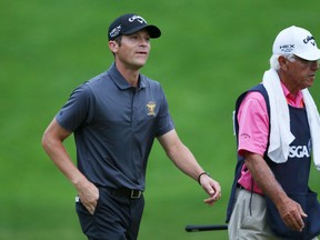 Jesse Smith (L) walks off the fourth green with his caddie David Glenz during the first round of the 2013 U.S. Open golf championship at the Merion Golf Club in Ardmore, Pennsylvania, June 13, 2013. (Adam Hunger Reuters)