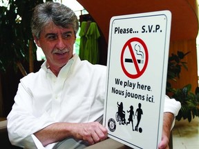 Dave McWilliam, manager of the chronic disease and injury prevention at KFL&A Public Health, looks at one of the signs that have been posted in area parks to raise awareness of the dangers of smoking around children. KFL&A Public Health has recently laid charges at 22 area retailers for selling tobacco products to people under 19.     Rob Mooy - Kingston This Week