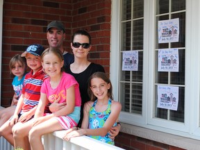 The Bibby family gathers on the front porch to display their personalized posters in support of Walk the Block. The Bibbys have family walking in Belleville, Whitby, Stirling and Texas. Front: Samantha, Tyler, Jesslyn, Meghan. Back: Mike and Stacey.