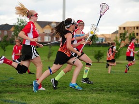 Owen Sound NorthStars under-13 player Hana Solinger runs the field 
maintaining ball possession as she guards off two Orillia players during an Ontario Women's Field Lacrosse game earlier this season.
