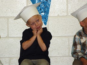 Alex McKinlay finds that graduation ceremonies take a long time during his kindergarten graduation in 2011 (QMI Agency file photo)