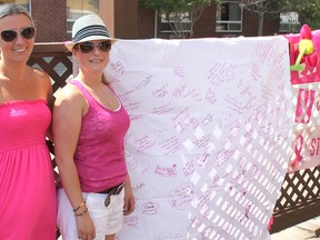 Paint Canada Pink Week in Timmins wrapped up Friday a patio party at East Side Mario’s. The week-long event promoted this fall’s CIBC Run for the Cure and raised funds and awareness for breast cancer research. Christine White and Kirsten Elvestad display a collector of supporter signatures that are, of course, in pink.
