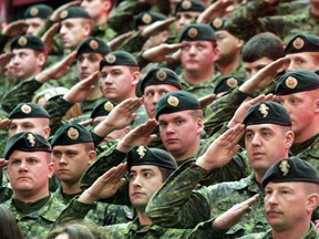 QMI Agency File Photo
Canadian soldiers in the crowd stand at attention as they salute during the playing of God Save The Queen.