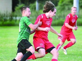 Tyler Bailey (12) of Stratford City FC is grabbed by Zarko Tolj of Guelph Oaks during a Kitchener District Soccer League Premier Division game at Packham Soccer Complex Friday night. (SCOTT WISHART, The Beacon Herald)