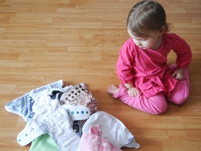 Charlotte Valade,2, looks at the different coloured cloth diapers that can be used during the annual world record Great Cloth Diaper Change, international event at the Ontario Early Years Centre. The purpose of the event is to bring awareness to the effectiveness of cloth diapers while setting a world record.  ERIKA GLASBERG/QMI AGENCY