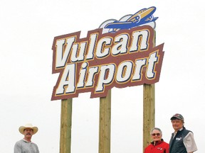 From left, Town development officer Jeff Johnstone and Centennial Committee co-chairs Louise Schmidt and Dave Munro in front of the Vulcan Airport's new sign.