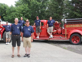 The Orford Fire Department celebrated 75 years of serving the Orford Township community with an open house on Saturday at their fire hall in Highgate. Firefighter Larry Garside, front left, who served as chair for the 75th anniversary event, is pictured with George Parry, Chief of Orford Fire Station No. 10. Other members of the volunteer station are pictured behind with a new International tanker/pumper truck and a 1938 GMC pumper truck, the station's first fire truck. ELLWOOD SHREVE/ THE CHATHAM DAILY NEWS/ QMI AGENCY