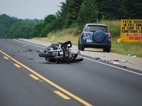 A motorcycle lies on Highbury Avenue near St. Thomas after colliding with two larger vehicles on Saturday, July 6, 2013. The motorcycle driver was airlifted to London Health Sciences Centre in critical condition, police said. Ben Forrest/QMI Agency/Times-Journal
