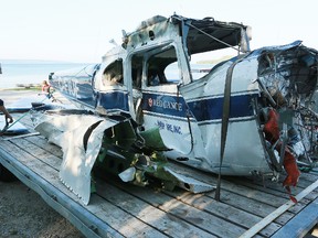 Peter Muehlegg of Salvair, a salvage company near Orillia, secures the damaged fuselage of a Cessna 182 float plane to a trailer at Big Bay east of Wiarton on Saturday, July 6, 2013. The fuselage and plane parts belonged to a float plane that crashed off Griffith Island on Thursday killing three Sudbury area men. (The Sun Times/JAMES MASTERS/QMI Agency)