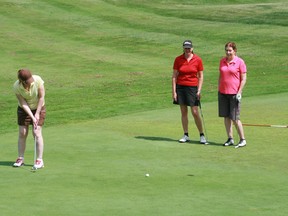 Ladies Open Golf Tournament 2013 overall champion Marcia Little sinks a putt on the 11th green as flight members Karen Lewis and Liz McKay observe her winning technique at Kenora Golf and Country Club, Sunday, July 7. This year's tournament attracted 27 players, including two from Dryden.
REG CLAYTON/Miner and News