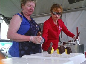 Rose Jackson, right, of Edible Arrangements, and her mother-in-law Vicki, prepare some chocolate-covered goodies during the 15th annual Taste of Kingston event, which took place Saturday in Confederation Park. (Vincent Matak For The Whig-Standard)