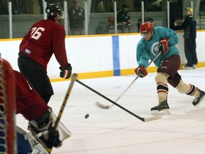 North Bay Jr. Trappers prospect Alex Grose of North Bay blasts a shot past defenseman Jordan Pettit (26) of Cambridge during a scrimmage Sunday during the club's main training camp at Pete Palangio Arena.