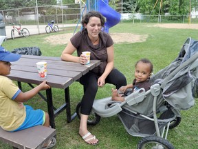 Miriam Turyanwijuka and her sons Zakaiah, 3, left, and Quran, 1, hang out at the new picnic table located in Prosvita Park during a PCRC community cleanup and barbecue on July 5. Other improvements were made to the park this spring, including mature trees and a bench. (CLARISE KLASSEN/PORTAGE DAILY GRAPHIC/QMI AGENCY)