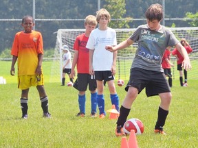 EDDIE CHAU Simcoe Reformer
Fourteen-year-old Hunter Lesage (right) works his way around the pylons while trying to maneuver a soccer ball while his friends watch on during the Challenger Sports British Soccer Camp Monday at the Norfolk Youth Soccer Park.