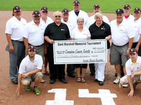 The Innerkip Umpires' Association and Judy Marshall donated $17,800 to the Oxford County unit of the Canadian Cancer Society July 7, 2013 at Innerkip Ball Park from money raised during the 10th annual Gord Marshall Ladies' Fastball Tournament. Since 2006, the tournament has raised $110,000 for the Cancer Society. The group were shown in front of Gord Marshall's No. 14, which he wore when he played with the Innerkip Eagles. (GREG COLGAN, Sentinel-Review)